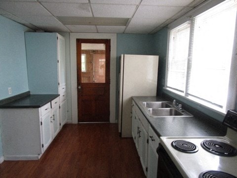 a kitchen with a stove and a sink and a refrigerator
