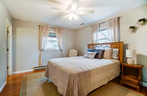 A bedroom with a large bed and a ceiling fan.