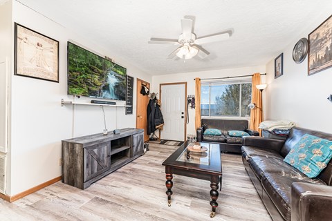 A living room with a brown leather couch and a wooden coffee table.