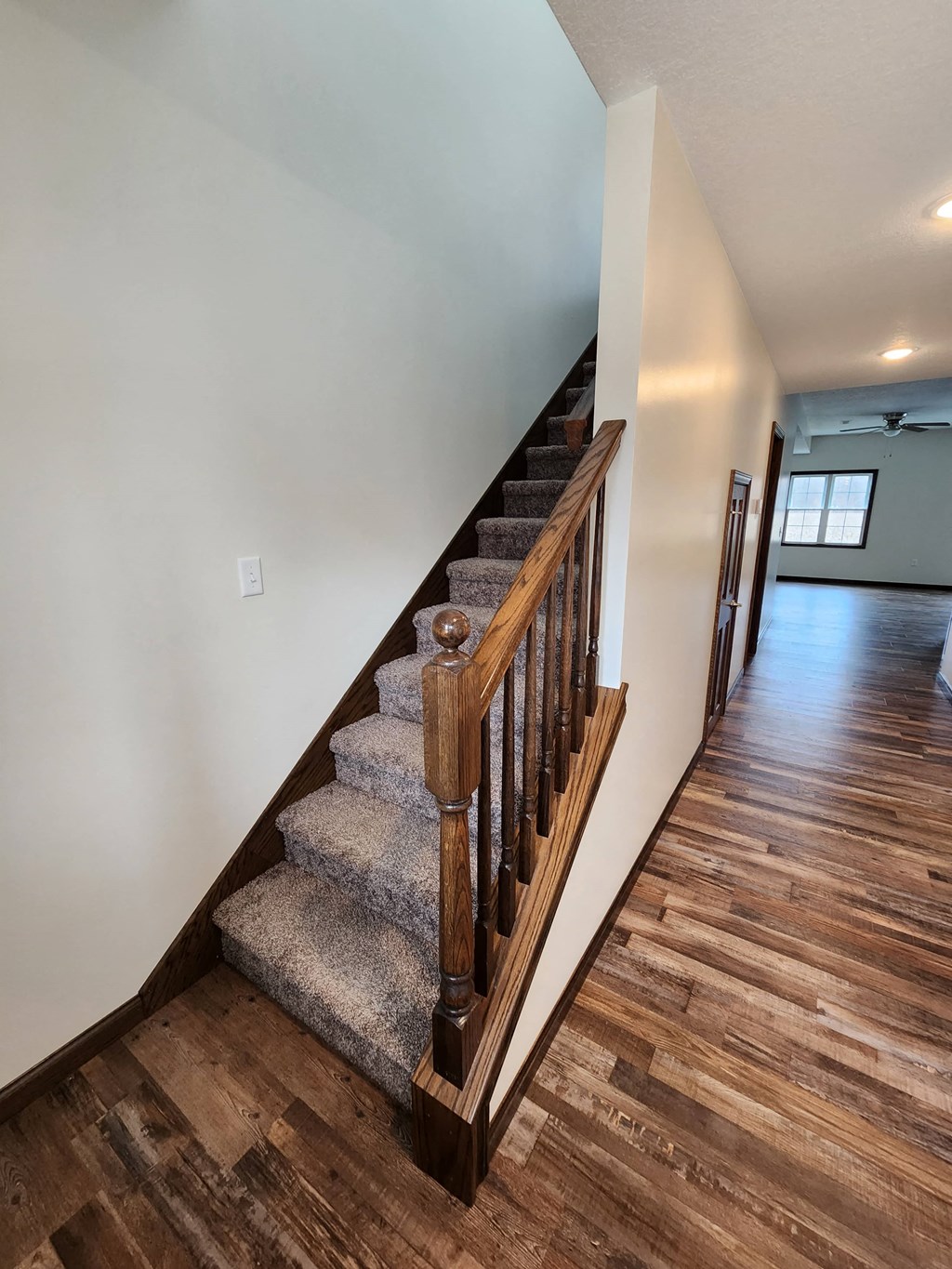 a staircase with hardwood floors and white walls