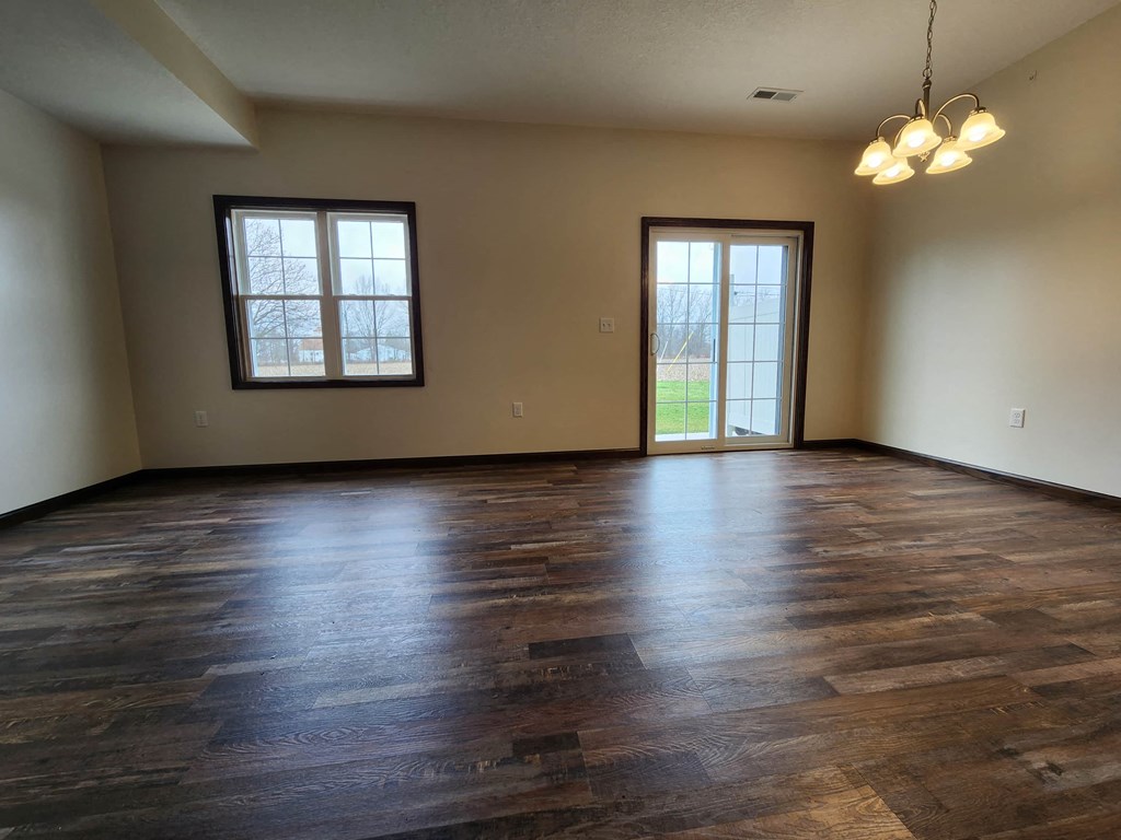 a empty living room with wood floors and a window