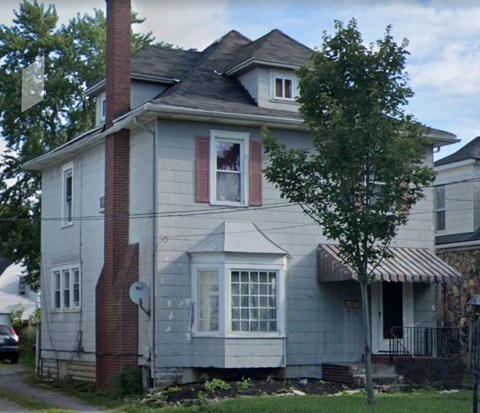 a white house with a window and a tree