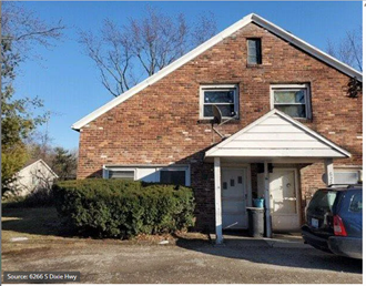 a brick house with a car parked in front of it