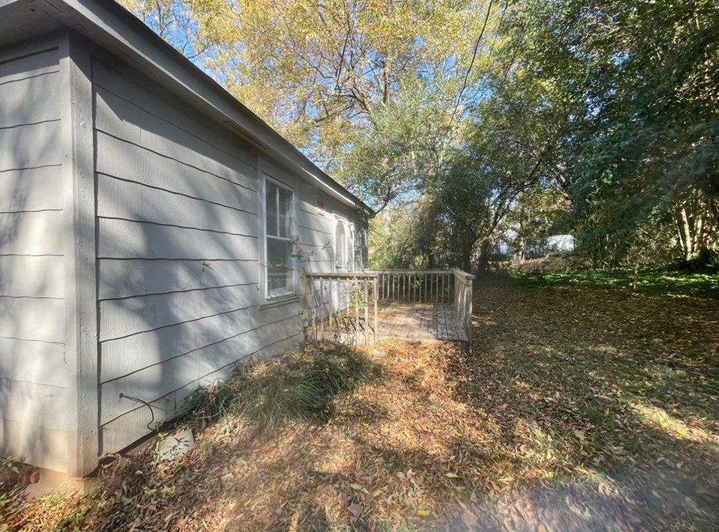the side of a house with a fence and a path next to it