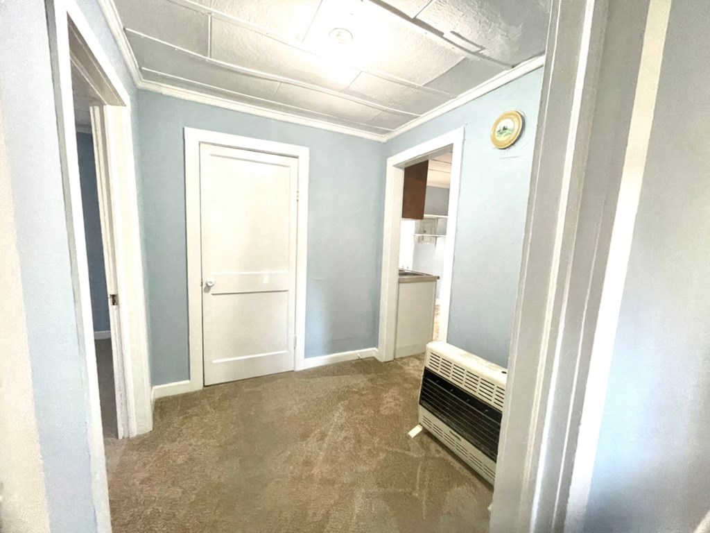 an empty room with blue walls and a door to a bathroom