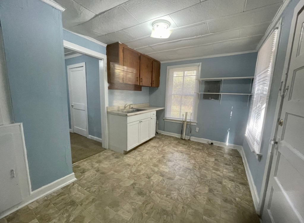 an empty kitchen with blue walls and a sink and a counter