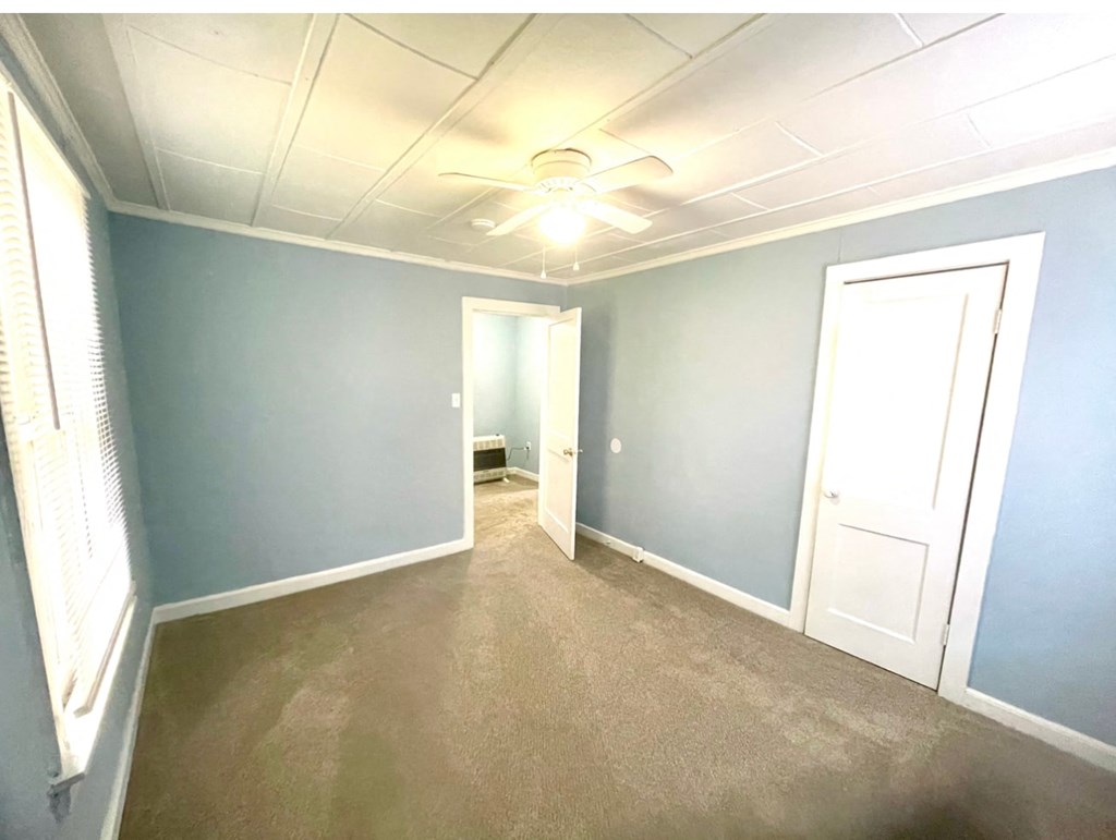 a empty room with blue walls and a ceiling fan