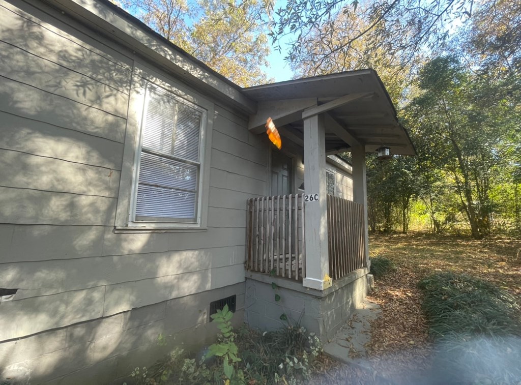 the front of a house with a porch and a fence
