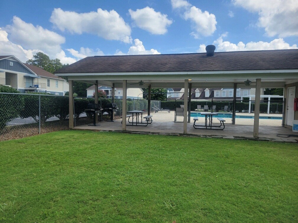 a covered patio with a pool in a backyard