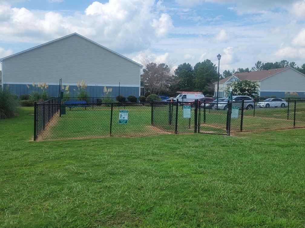 a fenced in dog park in the grass