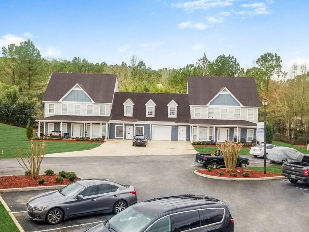 a large house with cars parked in a parking lot