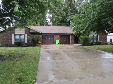 A house with a green door and a brown garage door.
