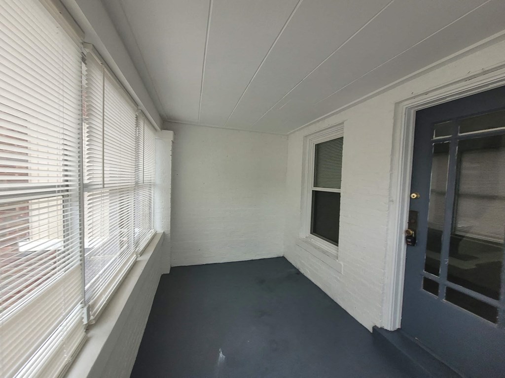 the living room of a house with a blue door and windows