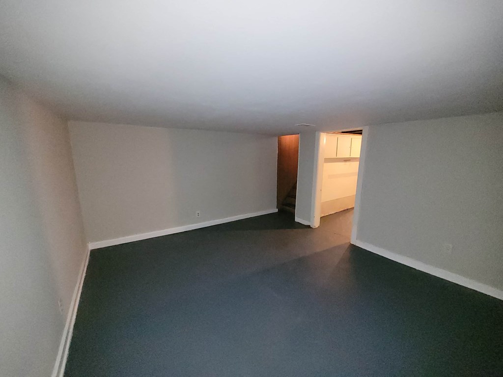 a empty room with a dark floor and white walls