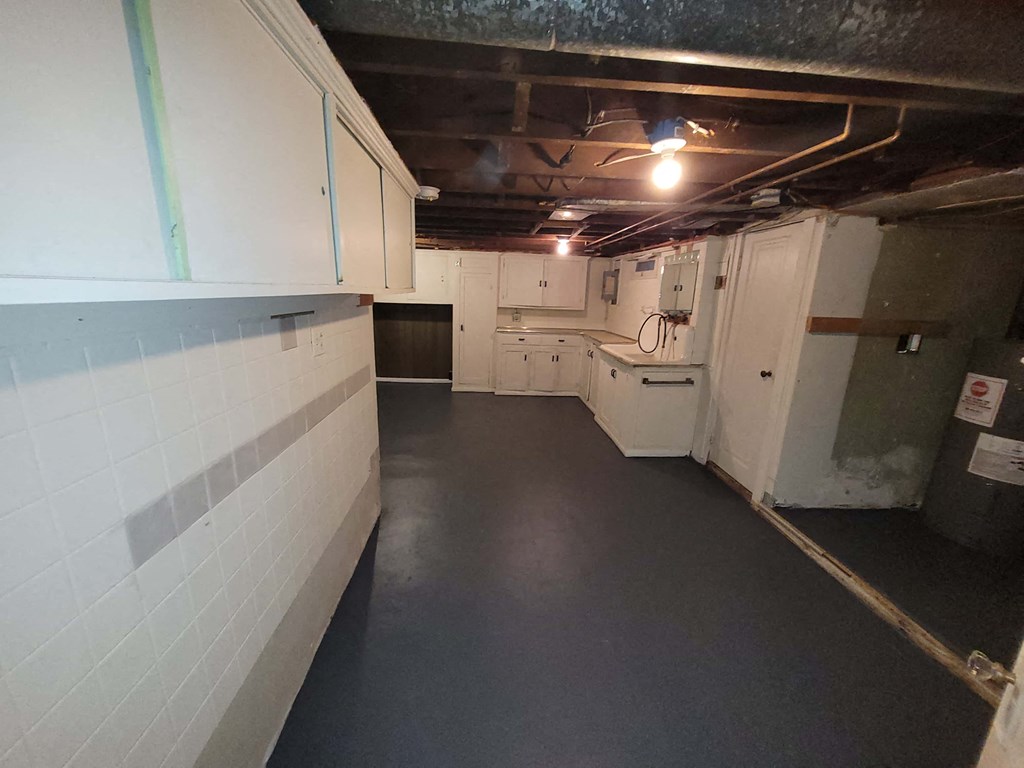 a large room with white cabinets and a dark floor