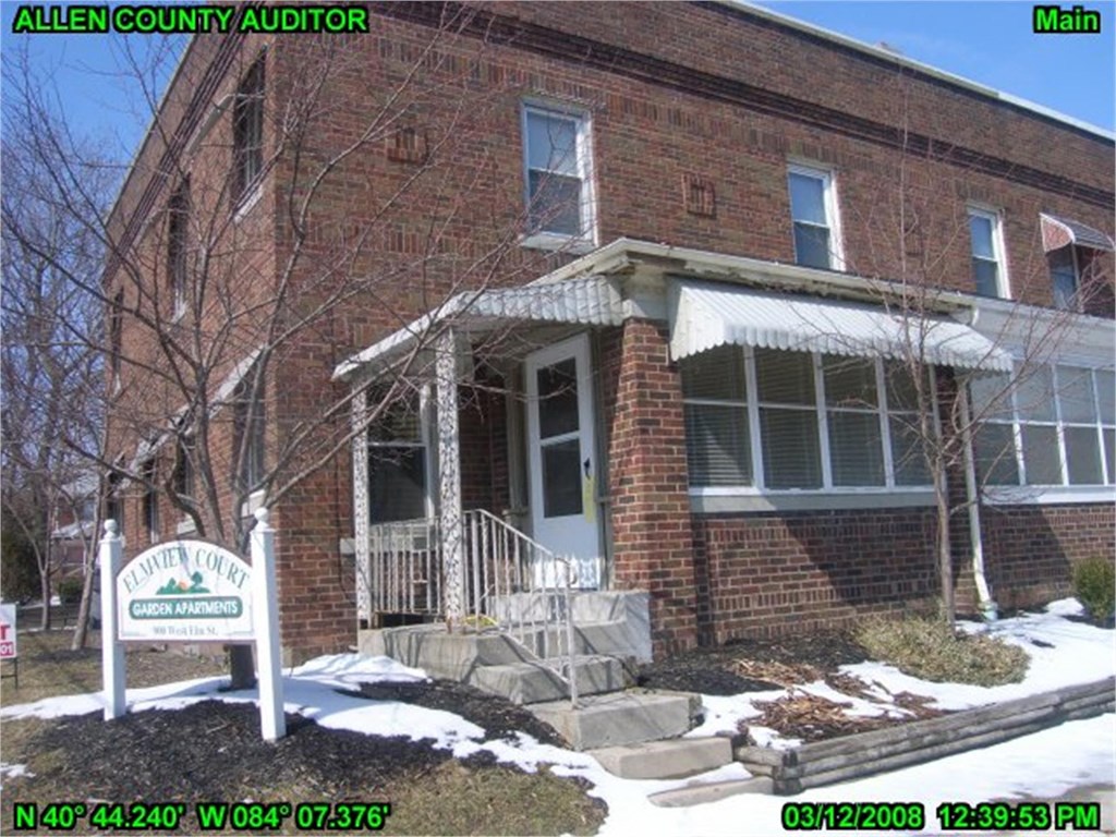 an old brick church with a white sign in the snow