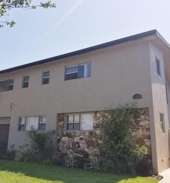 a building with a stone wall and windows on it