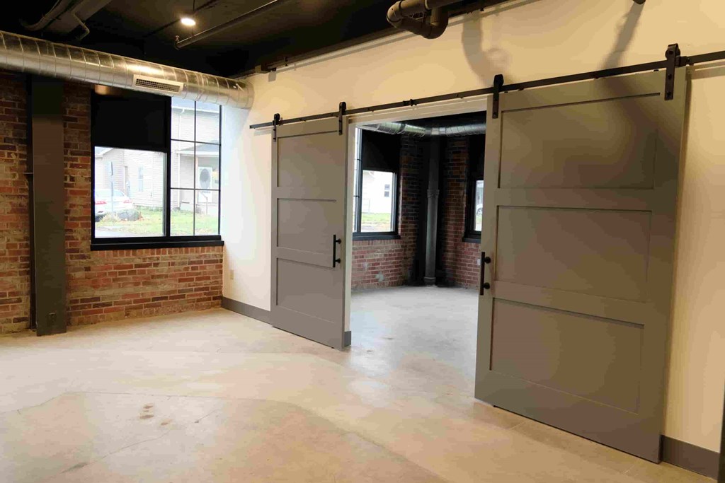 an empty room with a brick wall and sliding doors