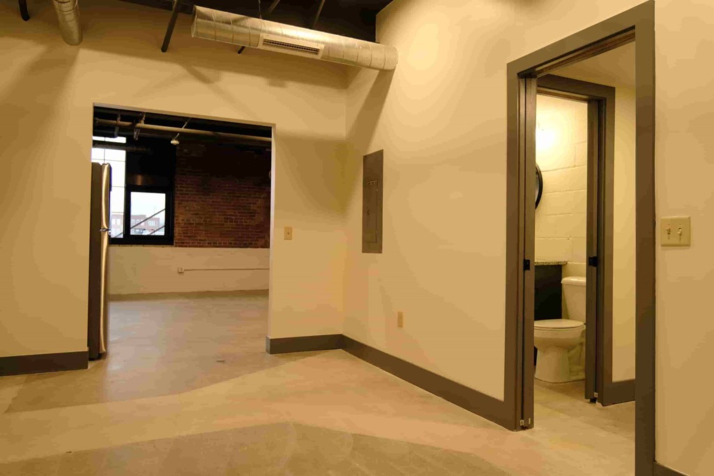 a large room with a toilet and a door to a bathroom