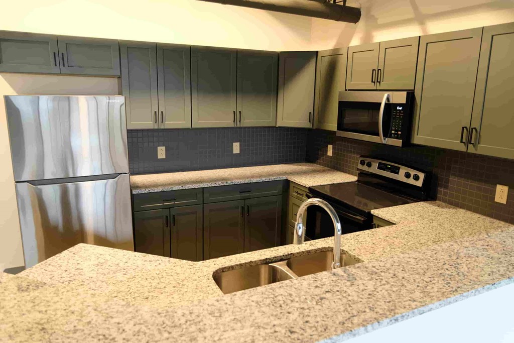 a kitchen with granite counter tops and stainless steel appliances