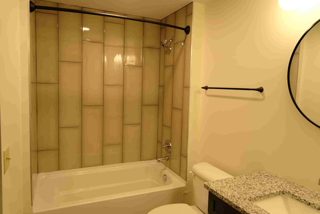 a bathroom with a shower and a toilet and a sink