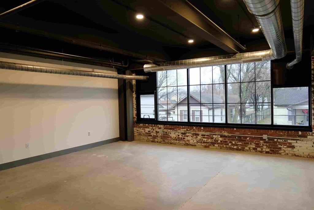 an empty room with a large window in the corner