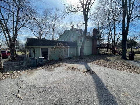 A house with a gravel driveway in front of it.