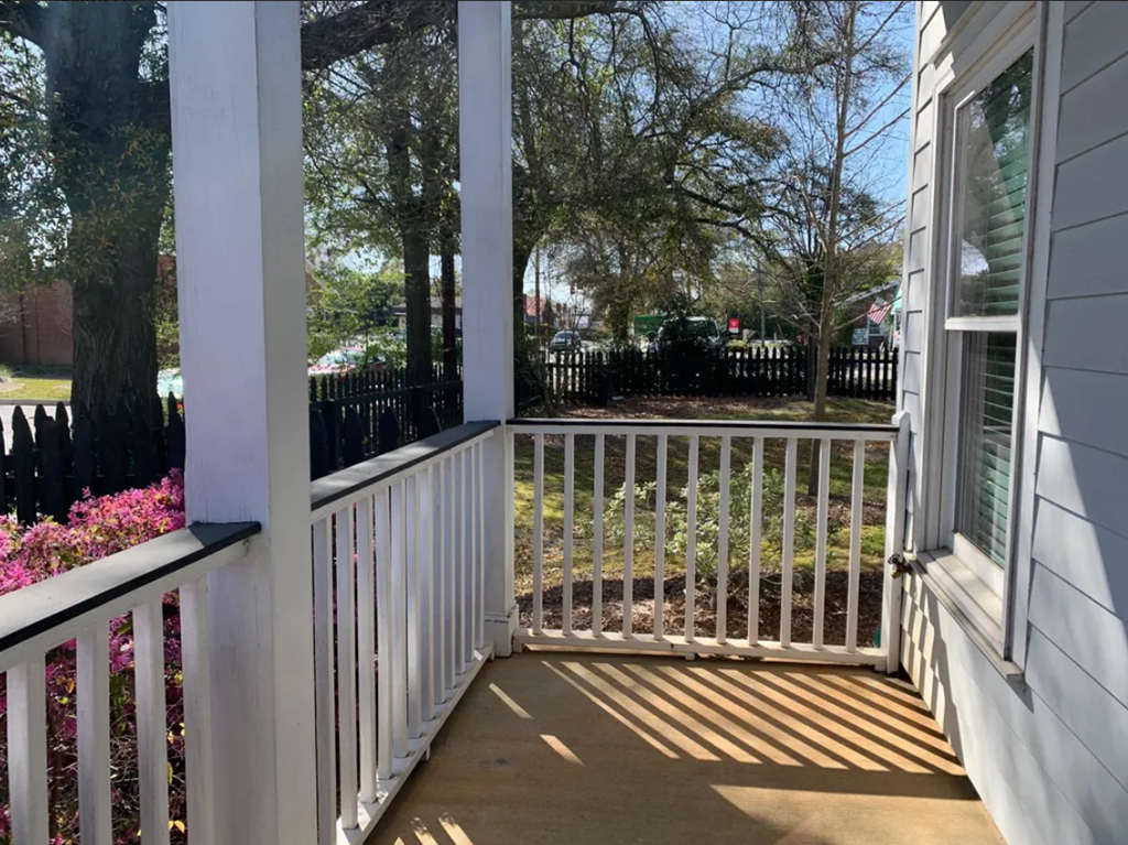 a balcony with a view of a yard and a house