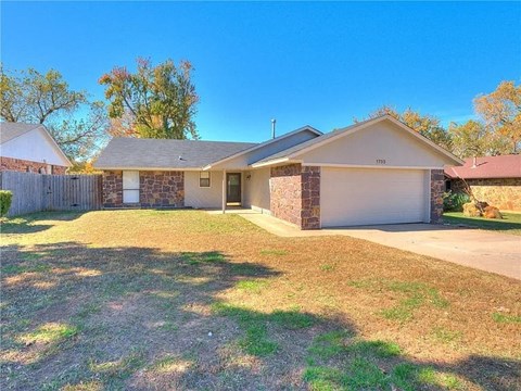 a small house with a yard and a driveway