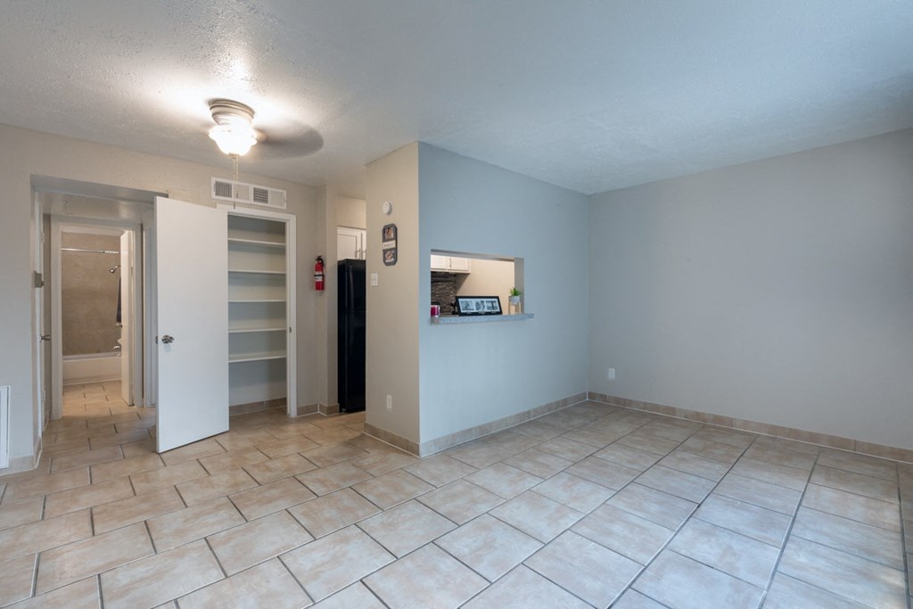 the living room of an empty house with tile flooring and a closet