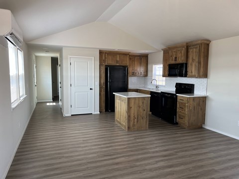 A kitchen with wooden cabinets and black appliances.