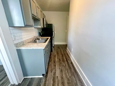 an empty kitchen with a sink and a refrigerator