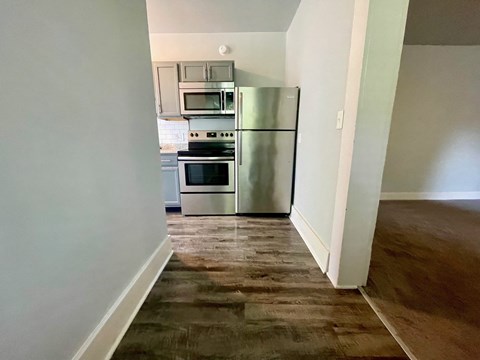 a kitchen with stainless steel appliances and a wooden floor
