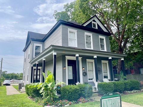 a house with a blue roof and a sidewalk