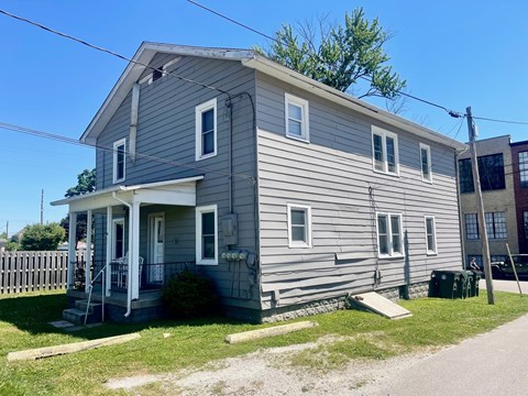 A grey house with a white door and windows.