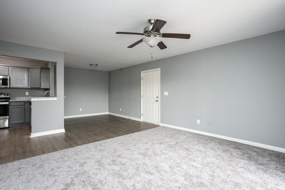 A room with a ceiling fan and a door.
