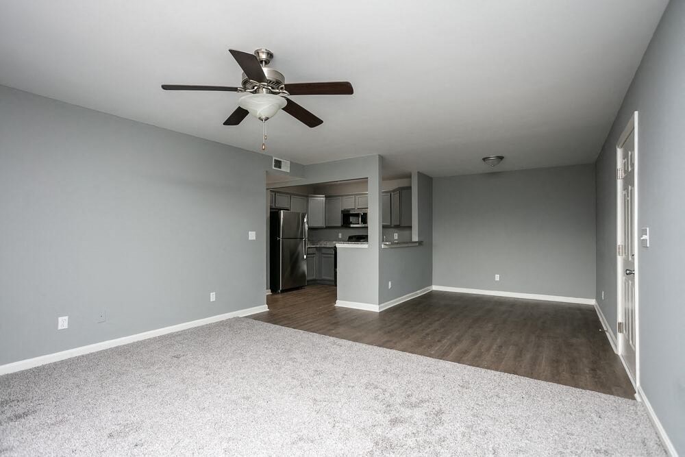 A room with a ceiling fan and a carpeted floor.