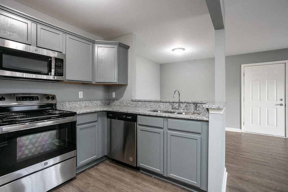 A kitchen with a stove, microwave, and dishwasher.