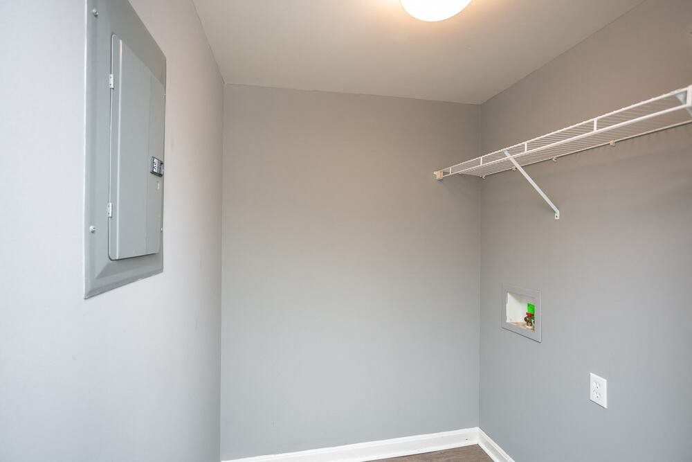 A white wall with a white shelf and a white door.