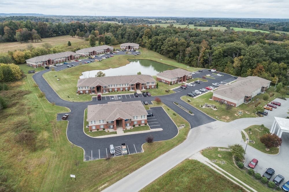 A large building complex with a parking lot in front.