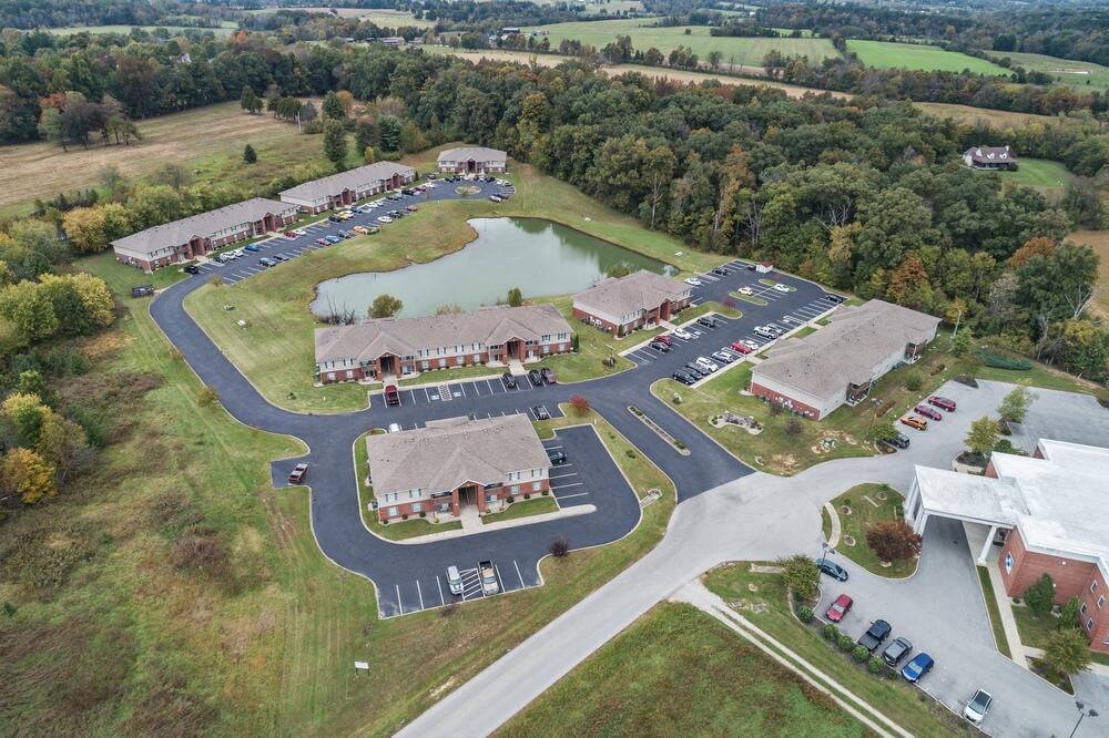 A large aerial view of a parking lot and buildings with a lake in the middle.