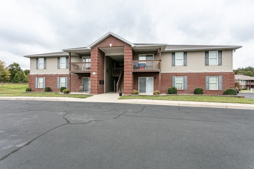 A large apartment building with a parking lot in front.
