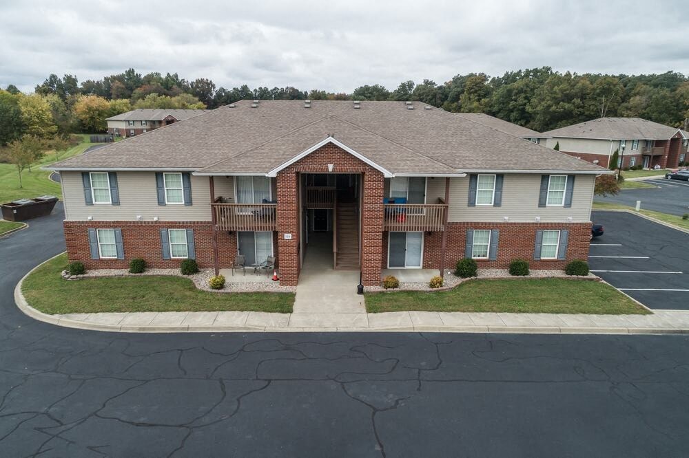 A brick house with a driveway in front.