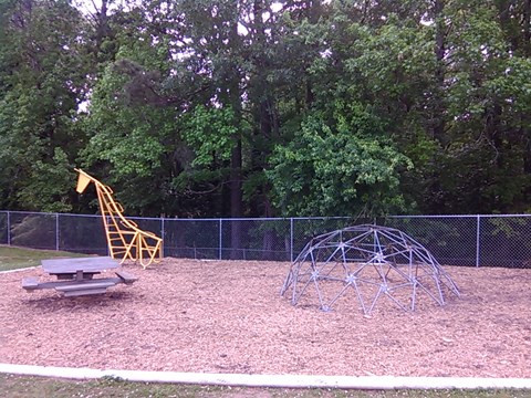 a playground with a swing set and a picnic table