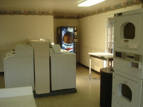 an empty laundry room with washing machines and a table