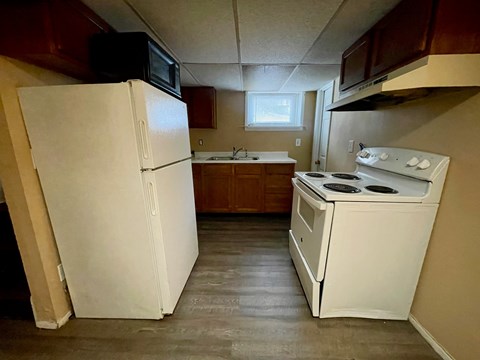 A small kitchen with a white refrigerator and a white stove top oven.
