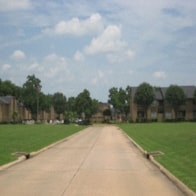 a dirt road with houses on the side of it