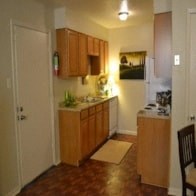 a small kitchen with wooden cabinets and a door