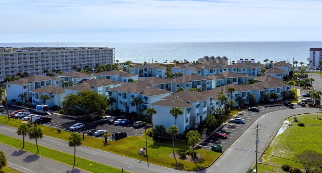 A view of a residential area with apartment buildings and a parking lot.