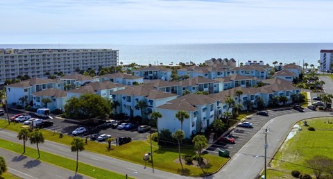 A view of a residential area with apartment buildings and a parking lot.